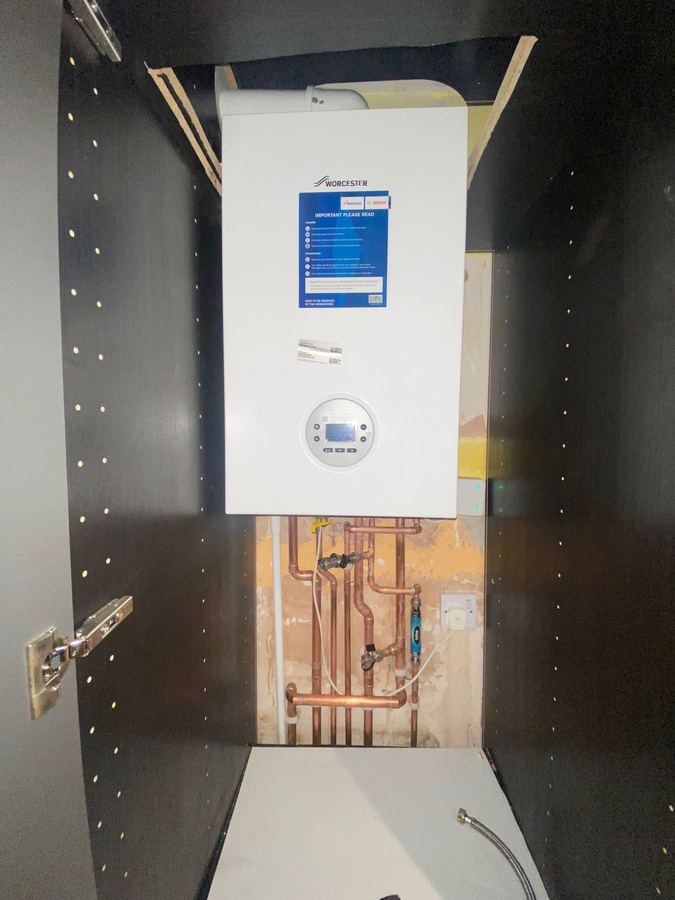Worcester Bosch combi boiler fitted inside a kitchen cupboard with tidy copper pipework